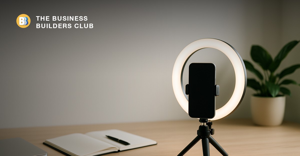 A content-creation setup with a ring light and a phone mounted on a tripod on a clean desk