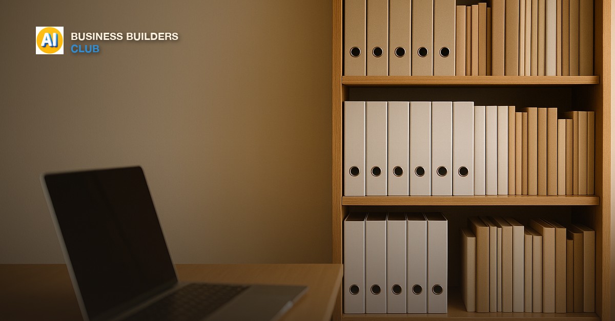 Organized bookshelf with binders and books beside a laptop on a wooden desk, warm indoor light