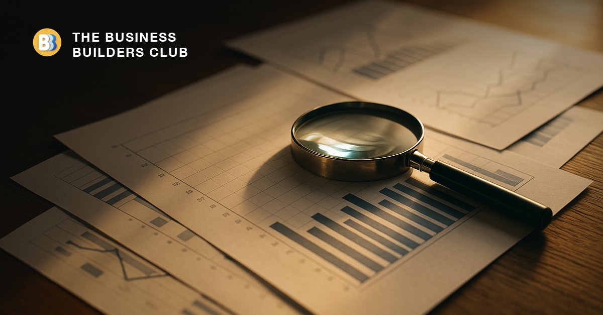 A magnifying glass resting on printed charts and graphs, standing in for market research